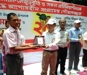 শহীদ পরিবারের প্রতিনিধির হাতে সম্মানা ক্রেস্ট তুলে দিচ্ছেন ইউপিডিএফ সভাপতি প্রসিত বিকাশ খীসা